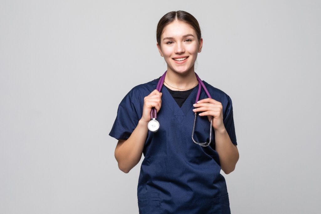 A nursing student wearing scrubs and holding a stethoscope.