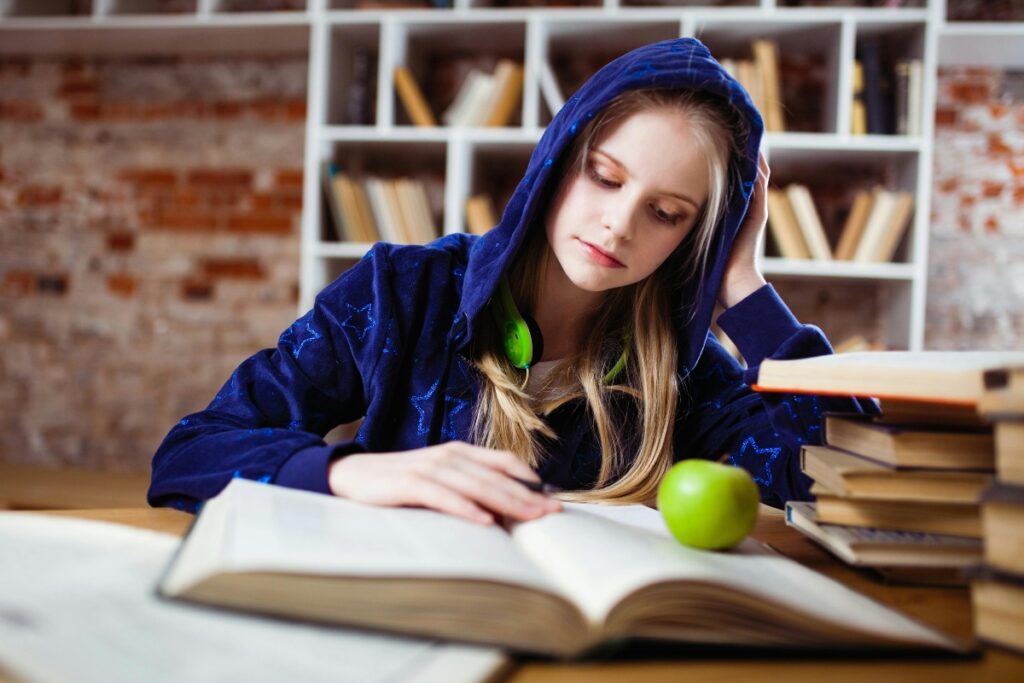 A girl studying from a large book.