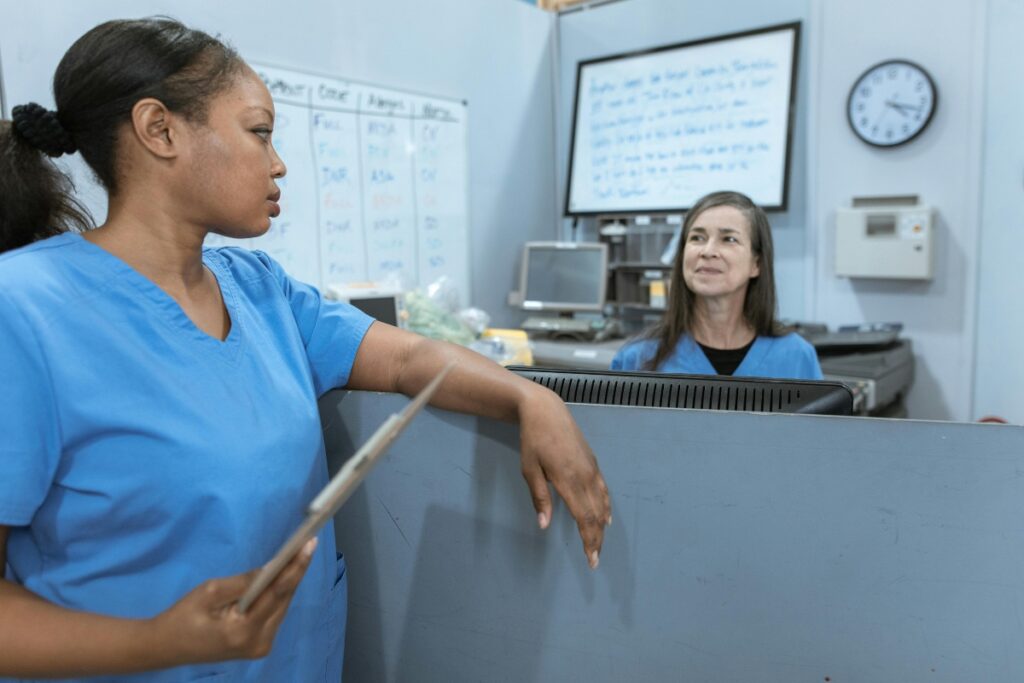 A RPN and RN talking in a hospital.