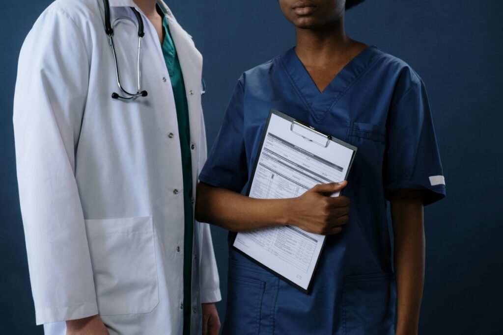A nurse with medical records and a doctor with a stethoscope.